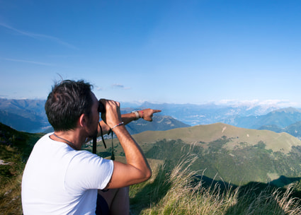 Mann schaut durch Feldstecher Uomo che guarda con il binocolo